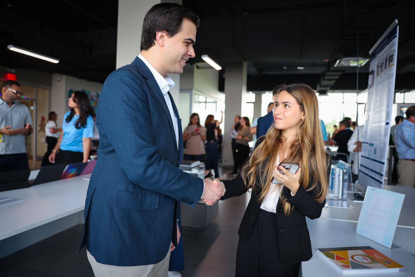 Lorena Pachiardi shaking hands at a research showcase